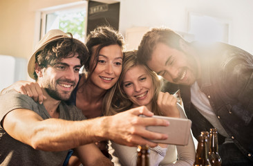 Friends taking selfies on a smartphone in a charming house. 