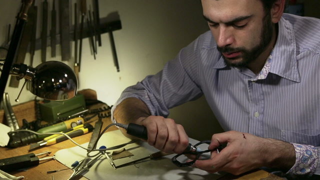 Young shopkeeper working in his glasses workshop   