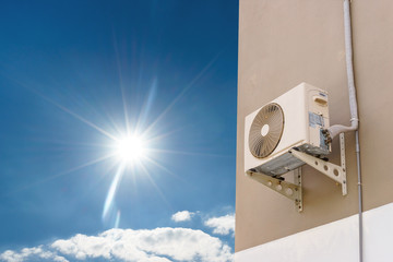 Air compressor on wall with blue sky and sunlight