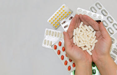 Obraz premium Template with pills in hands and bags of drugs on grey background
