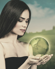 Beauty young woman with Earth globe in her hands
