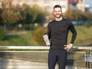 Young man jogging with plastic bottle