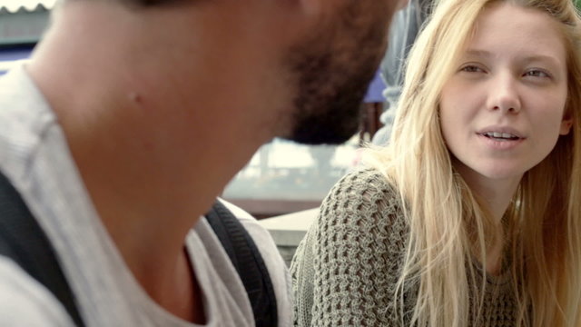 Man is chattering outdoor to a young beautiful blonde woman