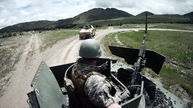 Humvee gunner gets help loading his machine gun.