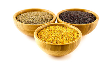 Ayurvedic spice combination in wooden bowls on white