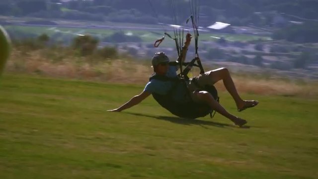 Male paraglider coming in for a landing at Point of the mountain, UT.