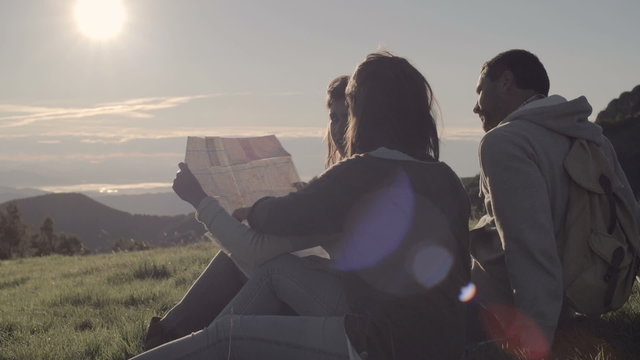 Friends doing camping looks at map in mountain