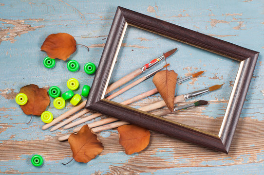 Paint brushes , paint and frame autumn