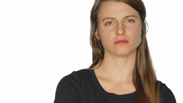 Angry young woman glares and shakes her head, on a white studio background