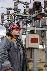 Obraz premium Electricians on high voltage substation