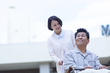 車椅子に座った笑顔の男性患者と女性看護師