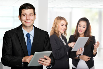 Young caucasian businessman, holding tablet pc. with his team