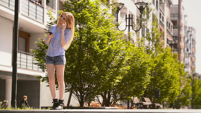 blonde woman walking at park listening music with smartphone   