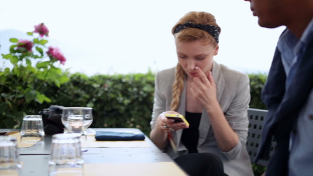Friends at italian restaurant are watching at smartphone