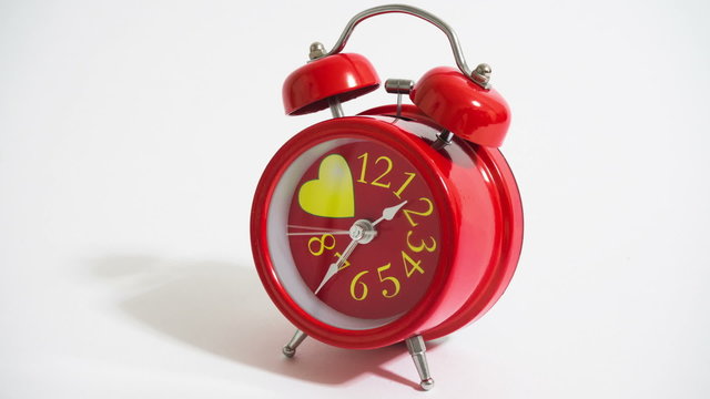 red alarm clock on a white background- timelapse