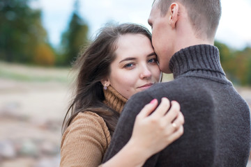 Fototapeta premium Young couple hugging on a rock on the beach