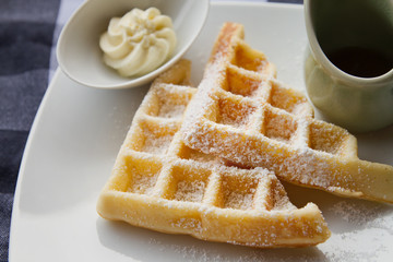 waffle with icing sugar, butter, syrup