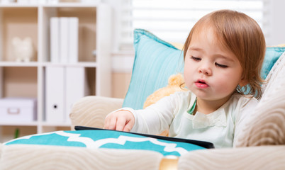 Toddler girl watching her tablet computer
