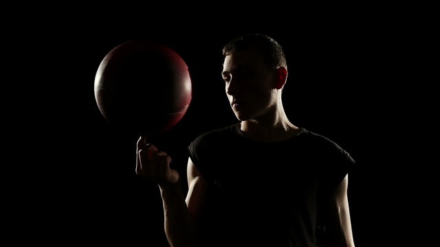 Young athletic sportsman perform basketball freestyle trick   