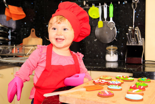 cute little girl making easter cookies in kitchen