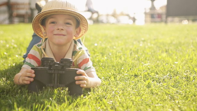 Child wearing pith helmet is playing at town park   