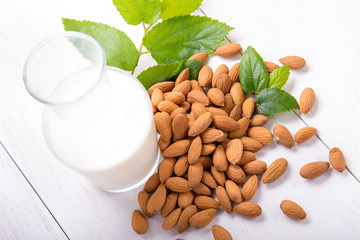 a bottle of almond milk with a pile of alond
