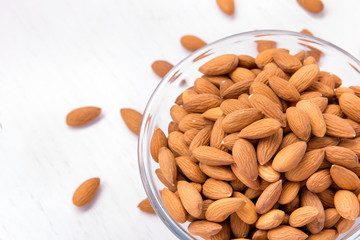 a bowl with almonds on white table