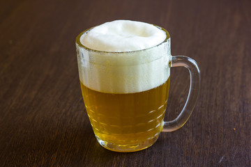 Mug of beer on wooden background