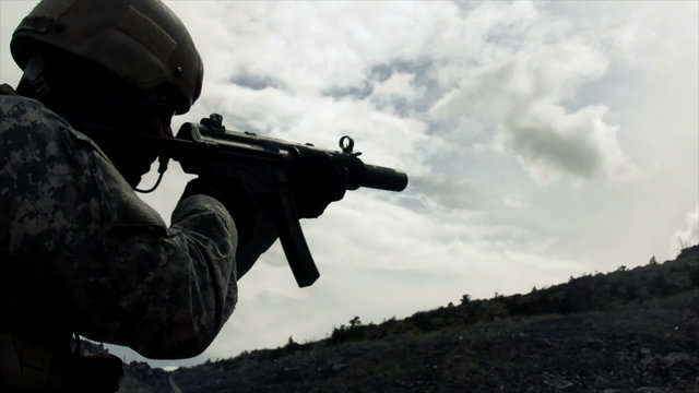 Static shot of soldier shooting automatic rifle.