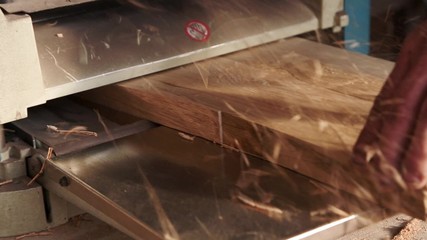 Joiner working on the planer in the carpentry workshop