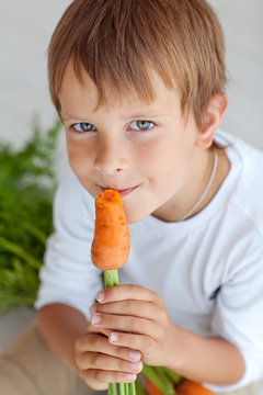 A kid are eating a carrot