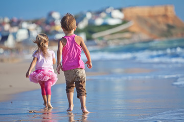 Fototapeta na wymiar Happy kids are running on the beach 