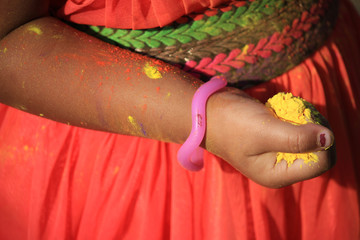 Child's hand with full of colors at Holi festival in India.