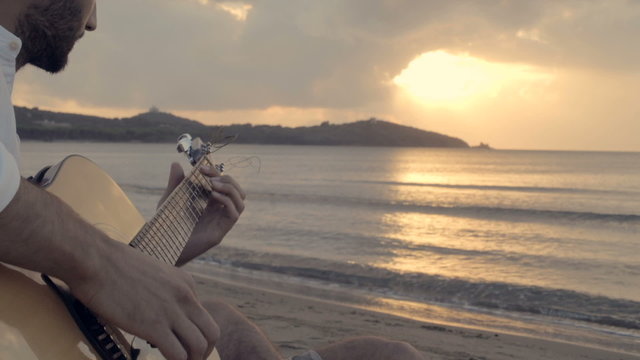 Man play guitar on beach at sunset  slow motion
