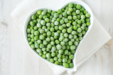 frozem peas on wooden surface