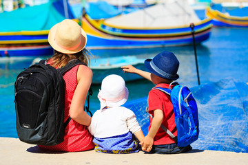 mother and two kids looking at traditional boats in Malta