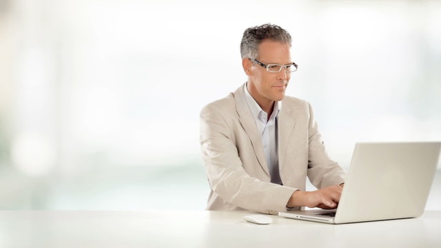 Elegant businessman is working on desk with his laptop   