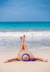 Fototapeta na wymiar woman with straw hat on the beach