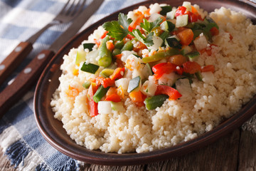 Asian Couscous with vegetables close-up on a plate. horizontal
