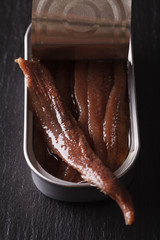 Canned anchovy fillets macro on a slate board. vertical
