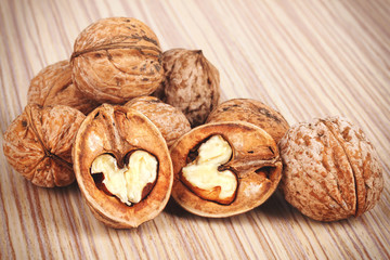 Group of cracked walnuts on wooden background