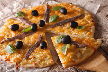 French Pissaladiere with anchovies and onions close-up. horizontal
