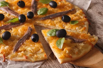 Pizza française aux anchois et oignons en gros plan. Horizontal