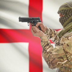 Male with gun in hands and national flag on background - England