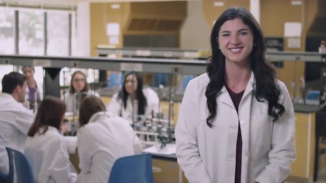 Portrait of a student in a science lab crossing her arms and smiling