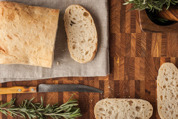 Fototapeta na wymiar Sliced bread on the wooden board with rosemary horizontal