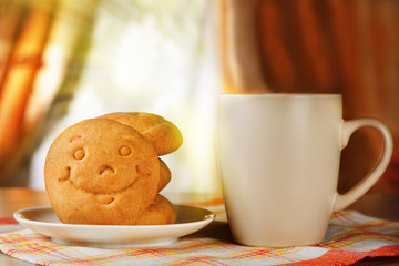 A hot drink and biscuit with a smile
