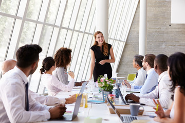 Caucasian Businesswoman Leading Meeting At Boardroom Table