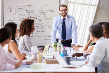 Fototapeta premium Caucasian Businessman Leading Meeting At Boardroom Table