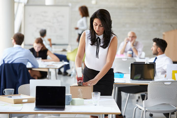 Businesswoman In Office Preparing Package For Shipping